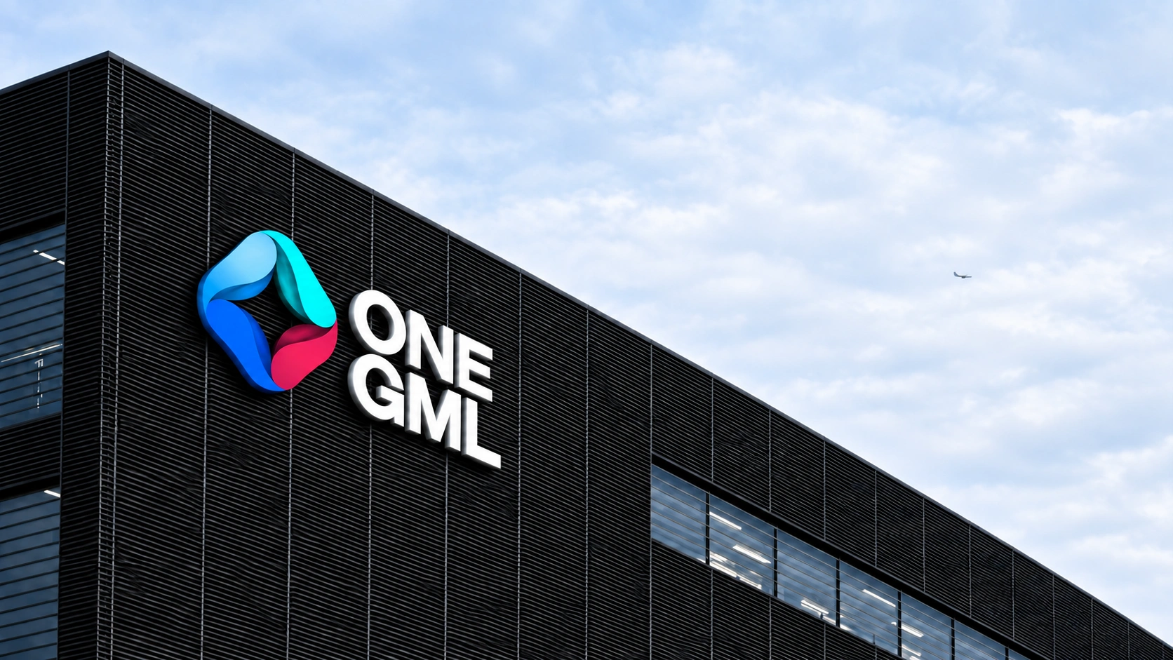 The ONE GML symbol and wordmark mounted on a contemporary dark building.
