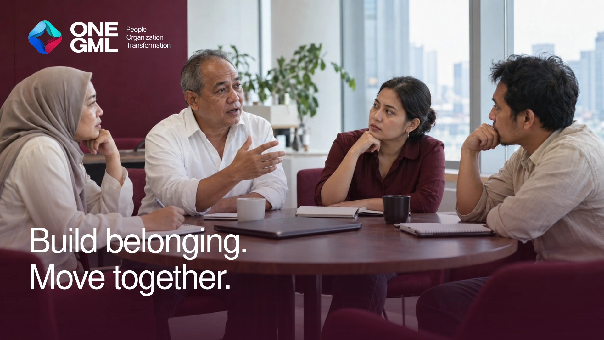 Four Indonesian colleagues sharing ideas around a meeting table, with natural skin tones and burgundy accents.